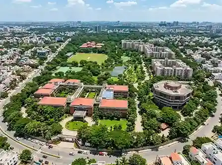 NLSIU Bangalore campus aerial view showing the 23-acre Nagarbhavi campus with academic blocks, library, hostel buildings, and green spaces of India's top-ranked law school
